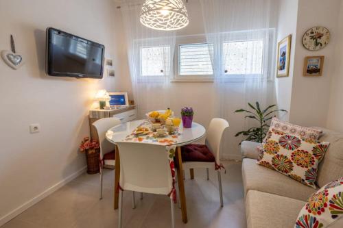 a small dining room with a table and a couch at Apartment Ljubav in Makarska