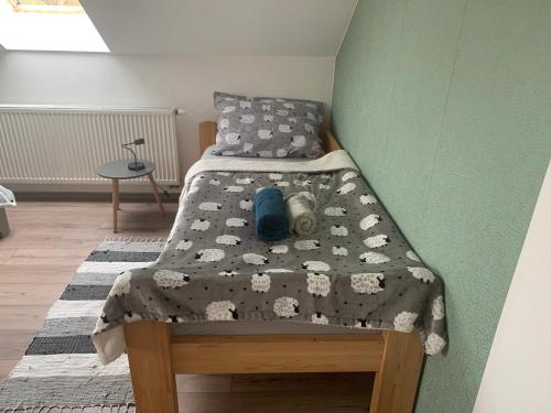 a small bed in a room with a green wall at Apartmán Stará cihelna in Klatovy