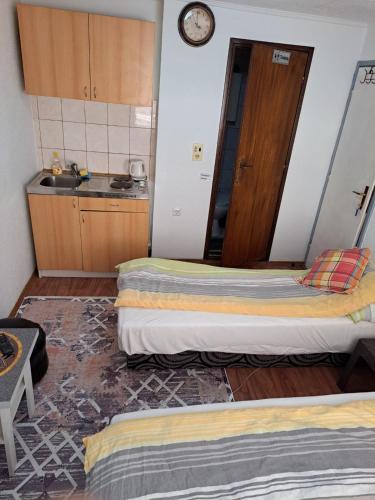 a room with two beds and a kitchen with a sink at Apartmani Konta in Livno