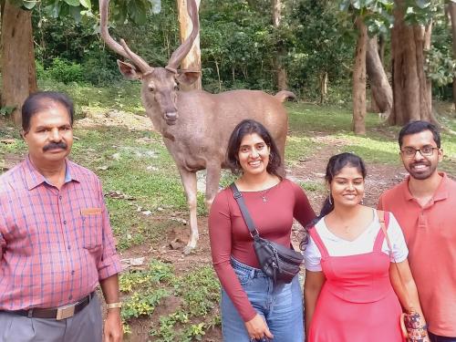 a group of people standing in front of a deer at Wild Window - Forest View Homestay in Thekkady