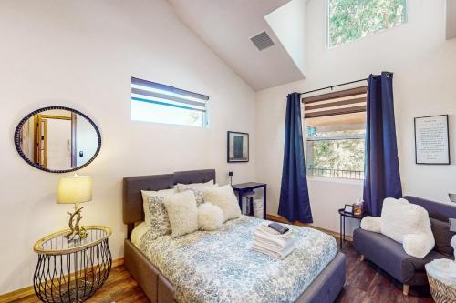 a bedroom with a bed and a couch and a mirror at Sweet Strawberry Cabin in Pine