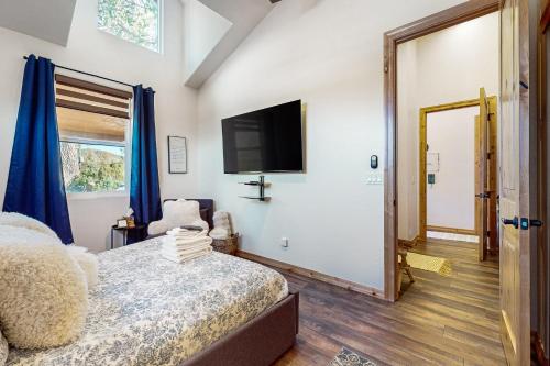 a bedroom with a bed and a flat screen tv at Sweet Strawberry Cabin in Pine