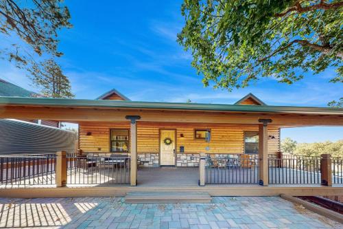a wooden house with a porch with a fence at Sweet Strawberry Cabin in Pine