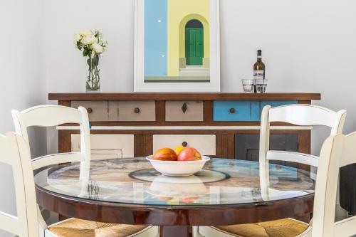 a dining room table with a bowl of fruit on it at Sliema Seaside Apartment Retreat in Sliema