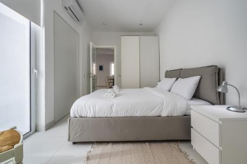 a bedroom with a bed with a teddy bear on it at Sliema Seaside Apartment Retreat in Sliema