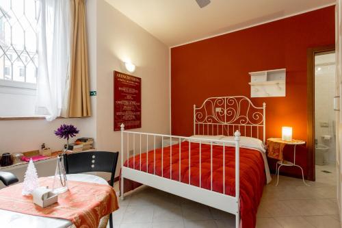 a bedroom with a white bed and a red wall at Alloggio Le Casette in Verona