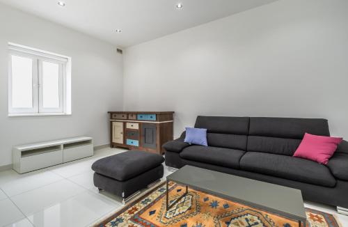 a living room with a black couch and a table at Sliema Seaside Apartment Retreat in Sliema