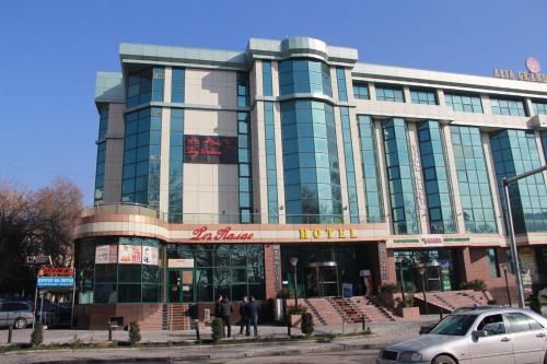 a building with a car parked in front of it at Taj Palace Hotel in Dushanbe