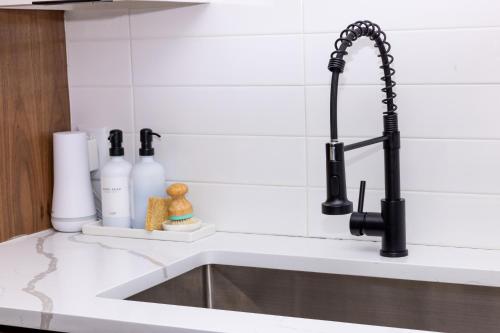 a kitchen sink with a black faucet at Luxe Retreat, Modern Gem with Private Backyard Oasis in Austin