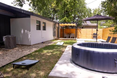 a backyard with a circular pool and an umbrella at Luxe Retreat, Modern Gem with Private Backyard Oasis in Austin