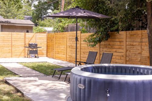 a patio with an umbrella and a table and chairs at Luxe Retreat, Modern Gem with Private Backyard Oasis in Austin