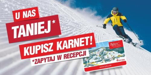 a man skiing down a snow covered slope with signs at Willa Hamernik AGROTURYSTYKA in Tylicz