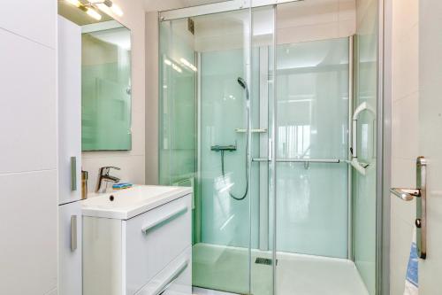 a bathroom with a glass shower and a sink at Pieds dans l'eau - Balcon vue mer in La Baule