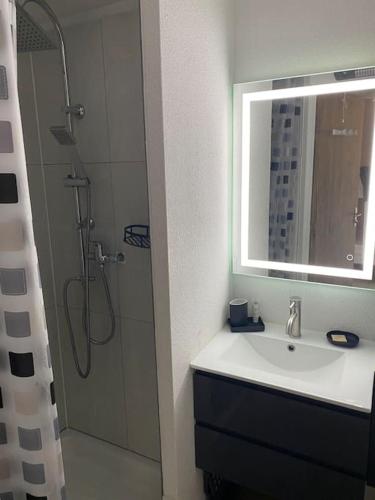 une salle de bain avec un lavabo et une douche avec un miroir dans l'établissement Apt T2 cabine climatisé à 1 min mer, balcon, piscine, au Cap d'Agde
