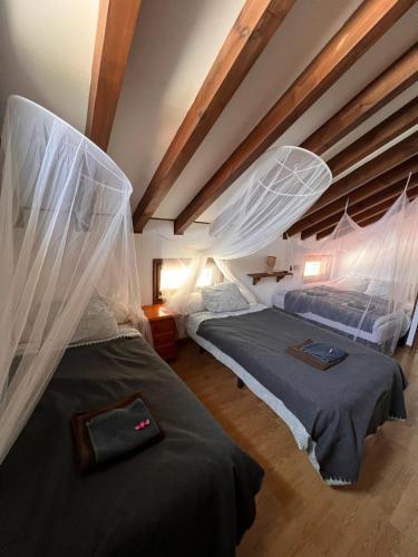 two beds in a room with white mosquito nets at Kite House Tarifa in Tarifa