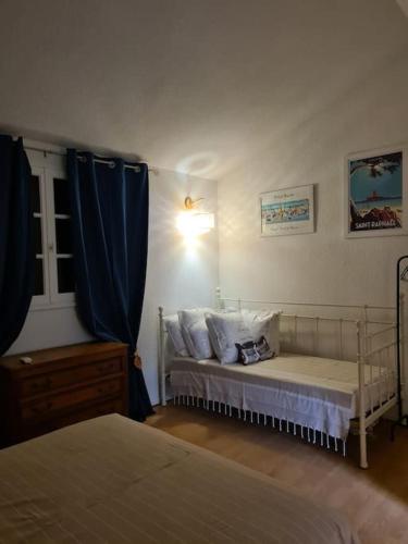 - une chambre avec 2 lits et un rideau bleu dans l'établissement Duplex cosy climatisé avec piscine St Raphael Boulouris, à Boulouris-sur-Mer