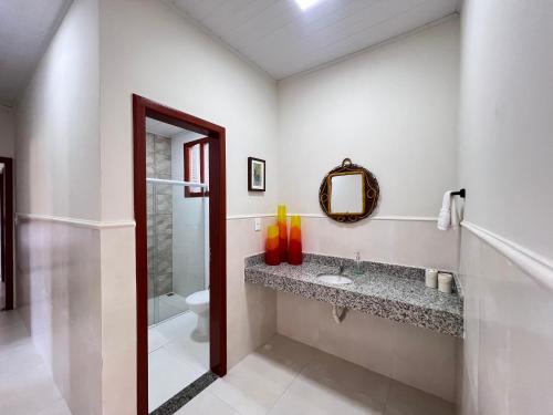 a bathroom with a sink and a toilet and a mirror at Casa Mares in Estância