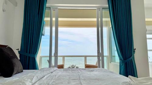 a bedroom with a bed with a view of the ocean at Luxury Oceanfront Penthouse in Uswetakeiyawa in Uswetakeiyawa