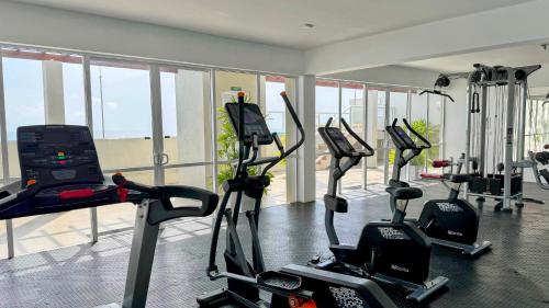 a gym with several treadmills and elliptical machines at Luxury Oceanfront Penthouse in Uswetakeiyawa in Uswetakeiyawa