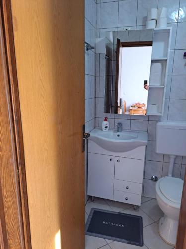 a bathroom with a sink and a toilet and a mirror at Apartmani Konta in Livno