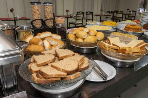 a buffet filled with bread and sandwiches and bread bowls at Hotel Vila Rica Belém in Belém