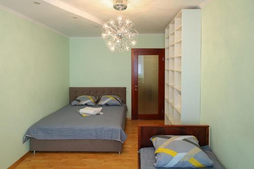 a bedroom with a bed and a chandelier at Квартира по улице Большая Васильковская, 129 in Kyiv