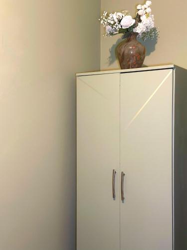 a white cabinet with a vase on top of it at The Rosemary Stay in Hull