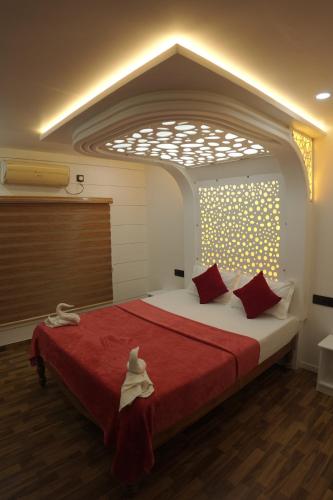 a bedroom with a large bed with red pillows at Vaishnav Tours in Alleppey