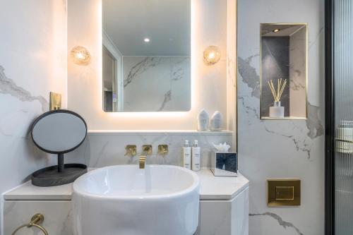 a white bathroom with a sink and a mirror at RÌGH Residences - George Street in Edinburgh