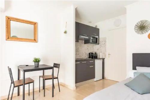 une cuisine et une salle à manger avec une table et des chaises dans l'établissement Ariane - Studio 23m2 - 5 min Plage - Climatisé, à Cannes