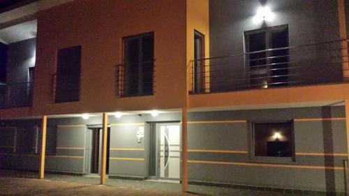 a building with doors and a balcony at night at Apartments Akacijev Izvir in Miklavž na Dravskem Polju