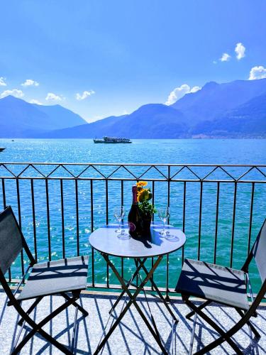a table and chairs on a balcony overlooking the water at On the Lake in Bellano