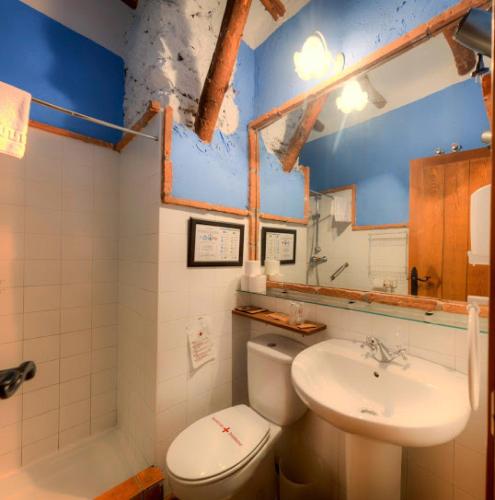 a bathroom with a white toilet and a sink at Cortijo Balzain in La Zubia