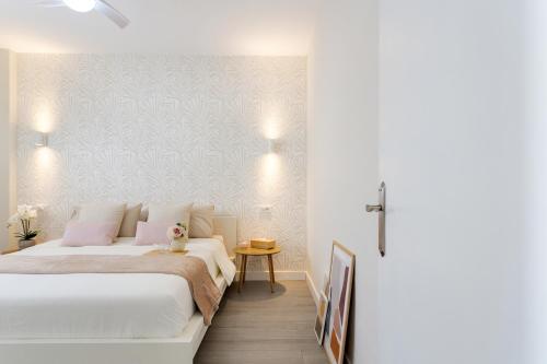 a white bedroom with a bed and a table at Martimar Candelaria in Candelaria