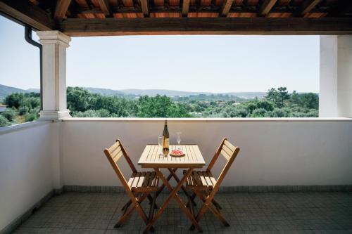 a table and chairs on a balcony with a view at Suíte Private balcony Hot Tub in Aguda