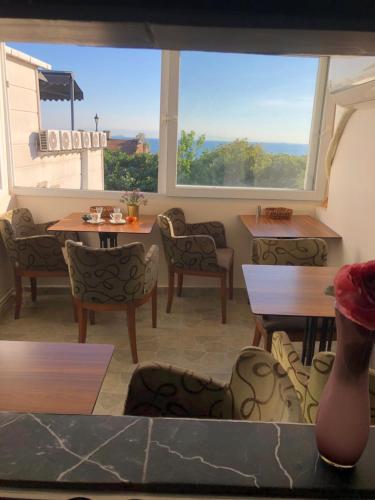 a restaurant with tables and chairs and a large window at BACHOS HOTEL SULTANAHMET sea view terrace in Istanbul