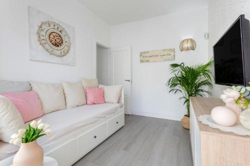 a living room with a white couch and a tv at Martimar Candelaria in Candelaria