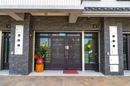 a front door of a building with a vase at 玉里木色香民宿 in Yuli
