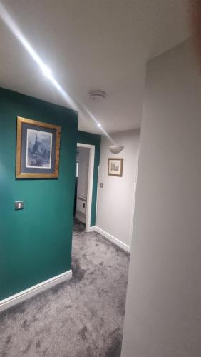an empty room with a green wall and a painting at St James's the gate in Newcastle upon Tyne