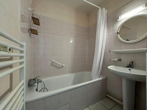une salle de bain avec une baignoire et un lavabo dans l'établissement Studio vue mer Saint Palais sur Mer, à Saint-Palais-sur-Mer