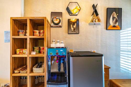 a room with a refrigerator and shelves with clocks on the wall at 玉里木色香民宿 in Yuli