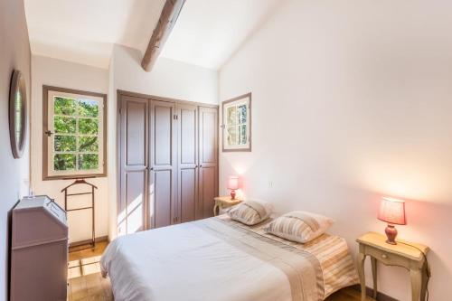 - une chambre blanche avec un lit et deux tables dans l'établissement La Luberone, à Ménerbes