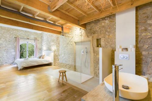 une salle de bain avec baignoire et un lit dans une chambre dans l'établissement Mas des Olivades, aux Baux-de-Provence
