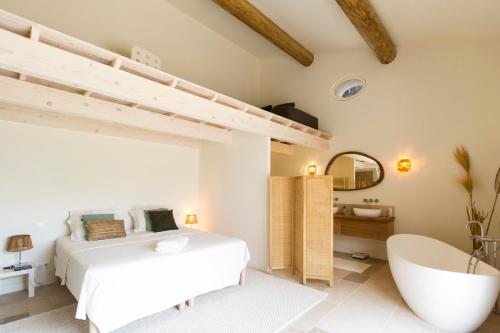 une chambre avec un grand lit et une baignoire dans l'établissement Mas des Olivades, aux Baux-de-Provence