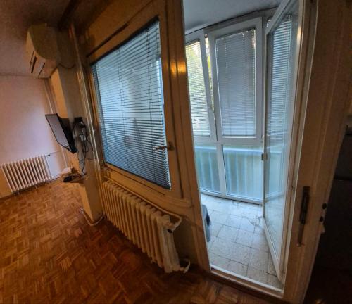 ein Zimmer mit einem großen Fenster mit Jalousien darauf in der Unterkunft Blok 1 in Belgrad
