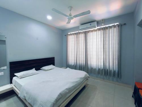 SānāwadHOTEL MUSHAK by BAPPA PALACE的带床和吊扇的卧室