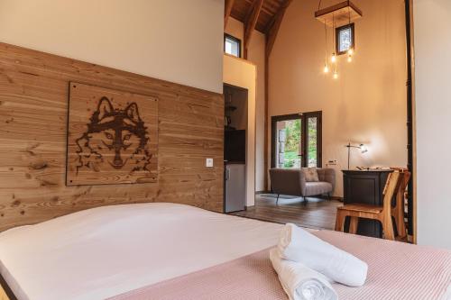 a bedroom with a bed with a wooden wall at Village de gîtes de Sainte-Lucie in Sainte-Lucie