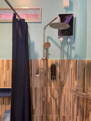 a shower in a bathroom with a shower curtain at Revolution Chiang Mai - Old Town in Chiang Mai