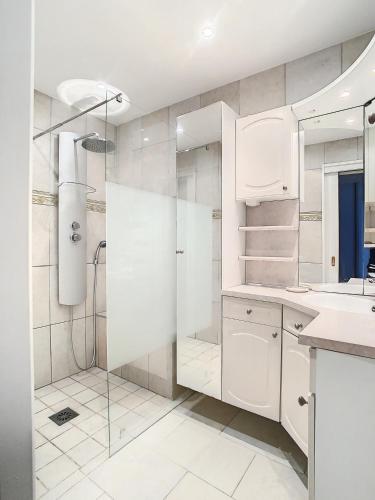 une salle de bain blanche avec une douche et un lavabo dans l'établissement Master - 4 pers 43m2 - Piscine - Climatisé, à Mandelieu-la-Napoule