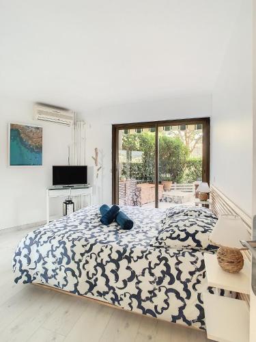 une chambre avec un lit avec une couverture bleue et blanche dans l'établissement Master - 4 pers 43m2 - Piscine - Climatisé, à Mandelieu-la-Napoule